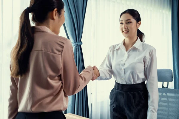 两名亚洲女商人在成功地分析了成堆的仪表盘数据文件之后 在现代办公室里握手 这是团队合作和诚信在工作场所概念中的重要性 很有激情 — 图库照片
