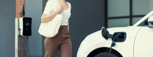 Progressive Asian Woman Electric Car Home Charging Station Concept Use — Stockfoto