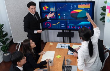 Confidence and asian businessman give presentation on financial analyzed by business intelligence in dashboard report to other people in board room meeting to promote harmony in workplace.