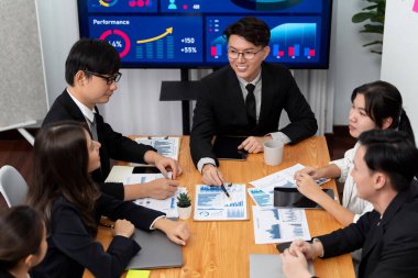 Business team of financial data analysis meeting with business intelligence, report paper and dashboard on laptop for marketing strategy. Business people working together to promote harmony in office.