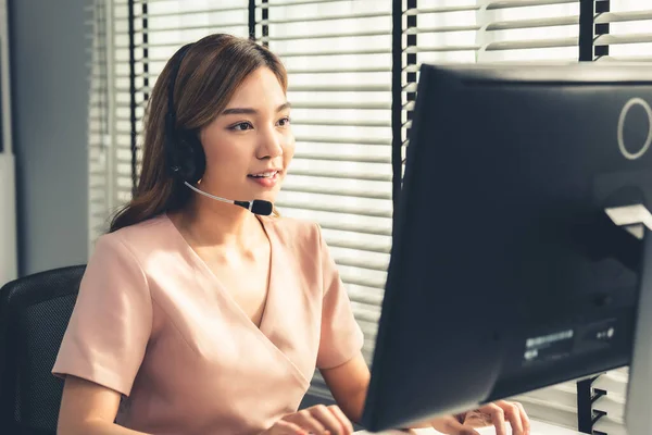 stock image Competent female operator working on computer and while talking with clients. Concept relevant to both call centers and customer service offices.