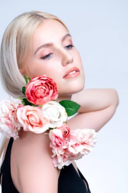 Closeup young personable woman with natural makeup and healthy soft skin holding rose for beauty care advertising in isolated background. Beautiful pretty model girl with flower concept.