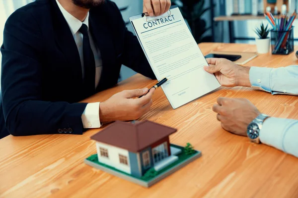 Client review loan contract with real estate agent, discussing term, interest and property ownership. Analyzing legal document, reading agreement before deciding. Real estate transaction. Fervent