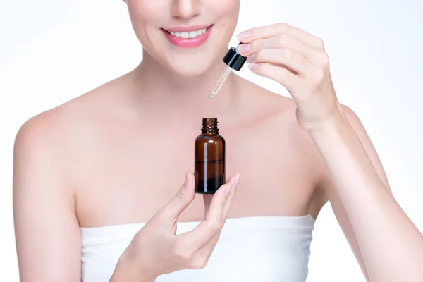 stock image Closeup personable portrait of beautiful woman applying essential oil bottle for skincare product. Cannabis extracted CBD oil dropper for treatment and cannabinoids concept in isolated background.