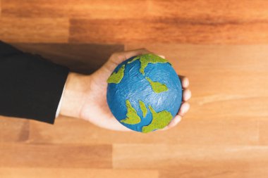 Üst düzey iş adamları kağıt toprağı masanın üstünde tutarlar. Temiz enerji ve sıfır CO2 emisyonu kullanan sürdürülebilir dünya için çevre bilinci. Yeşil politikası olan çevre dostu bir şirket. Değiştir