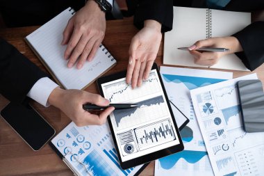 Ofisteki üst düzey analist ekibi veri analizi ve pazarlama stratejisini BI paneli ve tablet ekranda istatistik gösterimi kullanarak toplantı odasında iş performansını artırmak için tartışıyor. Sevinçli.