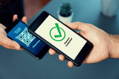 Parasız ödeme taraması için QR kodu ekranda görüntülendi. Kapalı eller, mobil uygulamadan elektronik işlem yoluyla para aktarmak için akıllı telefonu tutuyor. Hızlı ödeme için barkod teknolojisi. Coşkulu
