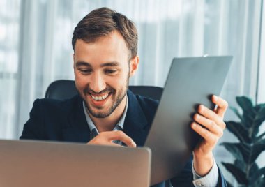 İşadamı ofis masasından sanal ofis toplantısı düzenliyor ve uzaktan çalışanlarla uzak iletişim kurmak için dizüstü bilgisayardaki Webinar uygulamasını kullanarak çevrimiçi video konferansını tartışıyor. Varlık