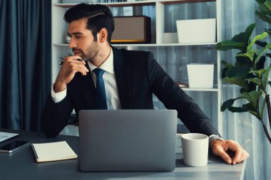 Modern ofis masasındaki modern profesyonel iş adamı çalışmak ve notlar yazmak için dizüstü bilgisayar kullanıyor. Ofisinde bilgisayar defteri üzerinde çalışan çalışkan bir ofis çalışanı. coşkulu