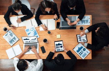 Top-view business team of financial data analysis meeting with business intelligence, report paper and dashboard on laptop for marketing strategy. Business people working together in office of harmony