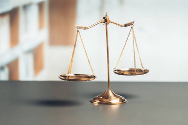 Mahkeme kütüphanesinin arka planında adalet ve adalet sembolü olarak parlak altın dengeli bir terazi. Avukat ve avukatın adil ve eşitlik kararı için terazi uygulayın. denge