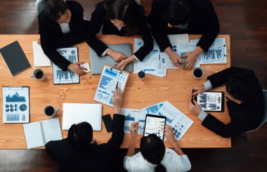 Top-view business team of financial data analysis meeting with business intelligence, report paper and dashboard on laptop for marketing strategy. Business people working together in office of harmony