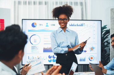 Genç Afrikalı iş kadını modern toplantıda TV ekranında veri analizi paneli sunuyor. Bir grup iş adamıyla konferans odasında iş sunumu. Uyum