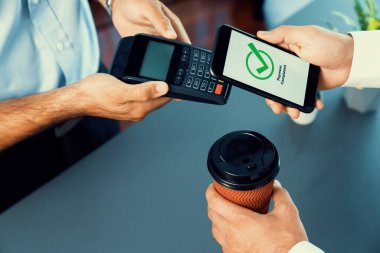 NFC QR kod cihazı ile el ele tutuşan akıllı telefon, hızlı dijital işlemler için temas kurulamayan ödeme kodlarını tarıyor. Modern yaşam tarzı ödeme teknolojisi için cep telefonundaki online bankacılık uygulaması. coşkulu