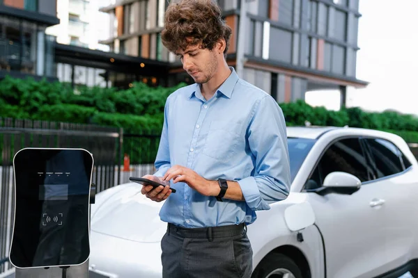 Suit Clad Progressive Businessman Look Cars Battery Status His Phone — Foto Stock