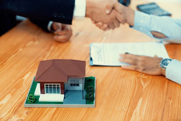 Successful house loan agreement sealed with a handshake. Buyers and agents celebrate the home ownership of property with a sense of accomplishment and satisfaction. Fervent