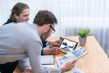 Ofisteki analist ekibi, iş performansını artırmak için tablet ekranında grafik ve grafik olan BI panelini kullanarak çalışma alanındaki pazarlama stratejisi için finansal veri analizi yapmakla meşgul. Varlık