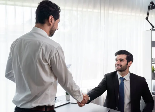 stock image Business partnership meeting with successful trade agreement with handshake or greeting in corporate office desk. Businessman in black suit shaking hand after finalized business deal. Fervent