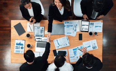 Top-view business team of financial data analysis meeting with business intelligence, report paper and dashboard on laptop for marketing strategy. Business people working together in office of harmony