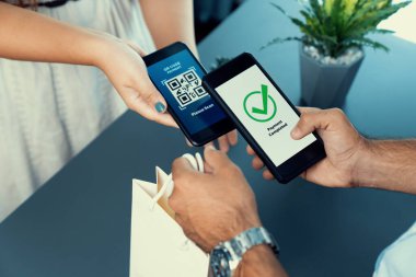 Parasız ödeme taraması için QR kodu ekranda görüntülendi. Kapalı eller, mobil uygulamadan elektronik işlem yoluyla para aktarmak için akıllı telefonu tutuyor. Hızlı ödeme için barkod teknolojisi. Coşkulu