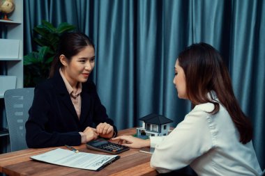 Temsilciyle ev kredisi sözleşmesini gözden geçiriyorum. Mali belgeleri ve vergi oranlarını, mülkiyet sahibi olmak için hesap makinesiyle analiz ediyorum. Yeni ev alımı ve finansman için anahtar imza. Coşkulu.