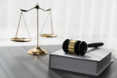 Adaleti ve hukuki otoriteyi temsil eden, altın dengeli ölçeği temsil eden ve avukatlık arka planında hukuk kitabı olan tokmağı, eşitlik ve adil yargı kavramını yansıtan. denge