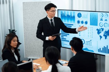 Confidence and asian businessman give presentation on financial analyzed by business intelligence in dashboard report to other people in board room meeting to promote harmony in workplace.