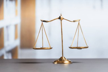 Mahkeme kütüphanesinin arka planında adalet ve adalet sembolü olarak parlak altın dengeli bir terazi. Avukat ve avukatın adil ve eşitlik kararı için terazi uygulayın. denge