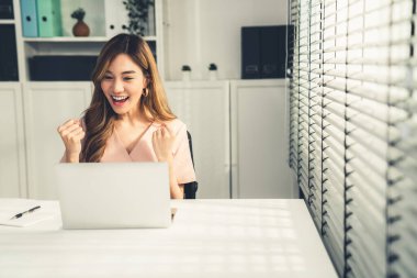 A young female employee receives a promotion, good news or finished her task and overjoyed for being a competent worker.