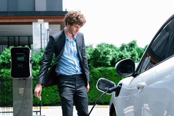 Progressive Businessman Wearing Black Suit Electric Car Recharging Public Parking — Zdjęcie stockowe