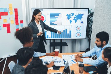 Genç Asyalı iş kadını modern toplantıda TV ekranında veri analizi paneli sunuyor. Bir grup iş adamıyla konferans odasında iş sunumu. Uyum