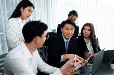 Harmony in office concept as business people analyzing dashboard paper together in workplace. Young colleagues give ideas at manager desk for discussion or strategy planning about project.