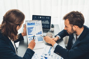 Ofisteki analist ekibi, iş performansını artırmak için bilgisayarında grafik ve çizelge olan BI gösterge panelini kullanarak çalışma alanındaki pazarlama stratejisi için finansal veri analizi yapmakla meşgul. Varlık