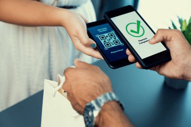 Parasız ödeme taraması için QR kodu ekranda görüntülendi. Kapalı eller, mobil uygulamadan elektronik işlem yoluyla para aktarmak için akıllı telefonu tutuyor. Hızlı ödeme için barkod teknolojisi. Coşkulu