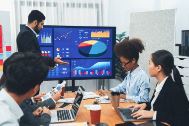 Pazarlama stratejisi için modern toplantıda veri analizi paneli ekranında sunan bir işadamı. Bir grup iş adamıyla konferans odasında iş sunumu. Uyum