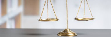 Mahkeme kütüphanesinin arka planında adalet ve adalet sembolü olarak parlak altın dengeli bir terazi. Avukat ve avukatın adil ve eşitlik kararı için terazi uygulayın. denge