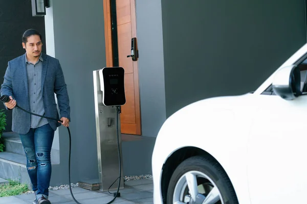 Progressive Asian Man Install Cable Plug His Electric Car Home — Foto de Stock
