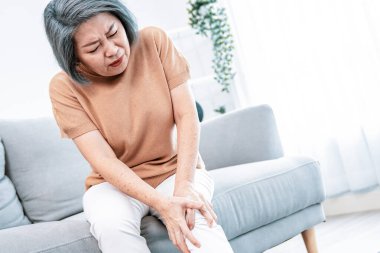 An agonizing elderly woman is experiencing chest pain. Medical attention, medical service for seniors.