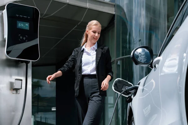 Progressive Businesswoman Wearing Suit Electric Car Recharging Public Parking Car —  Fotos de Stock