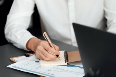 Closeup on BI dashboard on meeting desk with businesspeople analyzing or planning business strategy with hands pointing on financial paper reports as concept of harmony in office workplace.