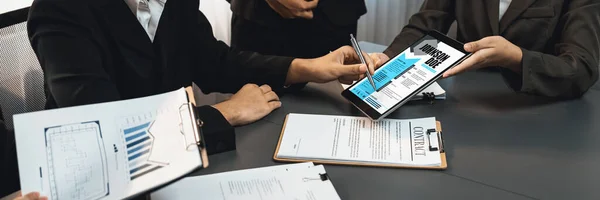 Candidate and interviewer discuss work experience and qualifications in job interview at corporate office. HR team evaluates job application on tablet while interviewee explaining her profile. Prodigy