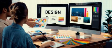 Grafik tasarımcısı, modern dijital stüdyo işyerinde profesyonel grafik ekibiyle benzersiz bir tasarım yaparken bilgisayar dizüstü bilgisayar ve grafik çizim kalemi üzerinde çalışır. Panorama çekimi. İnceleyin