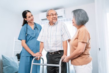 Contented senior man was helped on folding walking by his wife and caregiver. Recuperation for elderly, seniors care, nursing home.