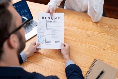 Aday özgeçmişini ya da CV 'yi şirket toplantı odasında mülakata veriyor. İş başvurusunda bulunan kişi, bilgisayar ekranında dijital özgeçmişiyle HR yöneticisine vasıflarını ve iş deneyimlerini göstermiş. Varlık