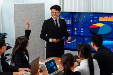 Confidence and asian businessman give presentation on financial analyzed by business intelligence in dashboard report to other people in board room meeting to promote harmony in workplace.