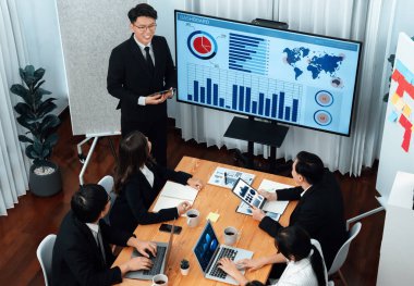 Confidence and asian businessman give presentation on financial analyzed by business intelligence in dashboard report to other people in board room meeting to promote harmony in workplace.