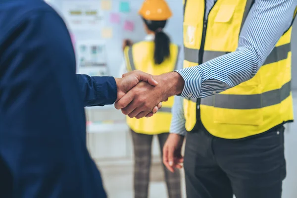 stock image After concluding the meeting, competent investor shakes hands with engineer. Concept of the agreement between engineers and investors.