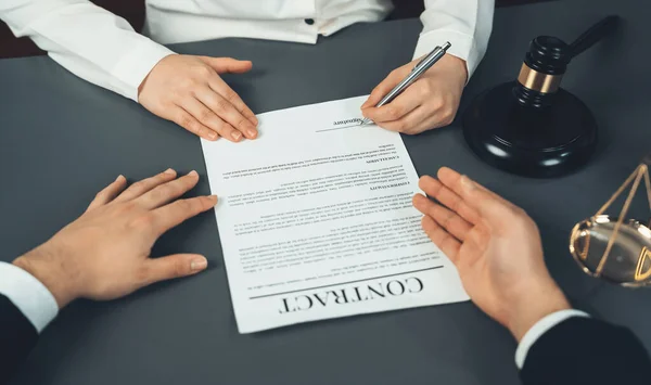 Lawyer signing contract, professional lawyer in law firm library drafting legal document or contract agreement ensuring lawful protection for clients dispute as fairness advocate concept. Equilibrium