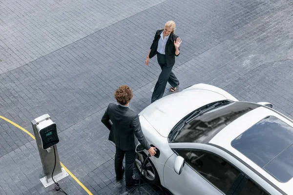 자동차를 사업가들의 진보적 도심의 주차장에 주유소와 연결되어 공중에서 수있다 에너지를 — 스톡 사진