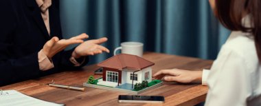 Temsilciyle ev kredisi sözleşmesini gözden geçiriyorum. Mali belgeleri ve vergi oranlarını, mülkiyet sahibi olmak için hesap makinesiyle analiz ediyorum. Yeni ev alımı ve finansman için anahtar imza. Coşkulu.